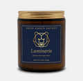 Luminaria coffee candle in an amber glass jar with a navy and gold Snow Dance Society label