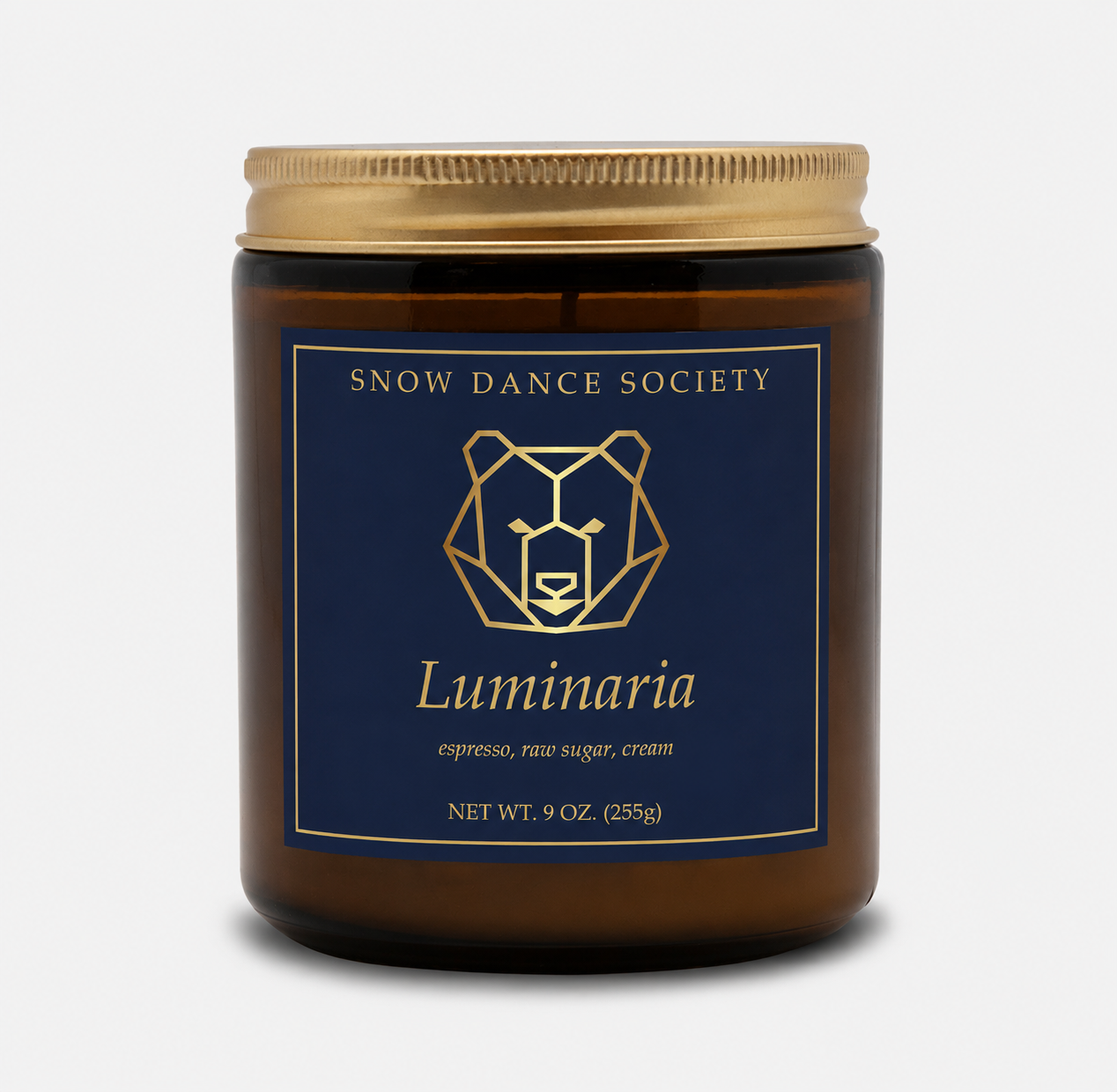 Luminaria coffee candle in an amber glass jar with a navy and gold Snow Dance Society label